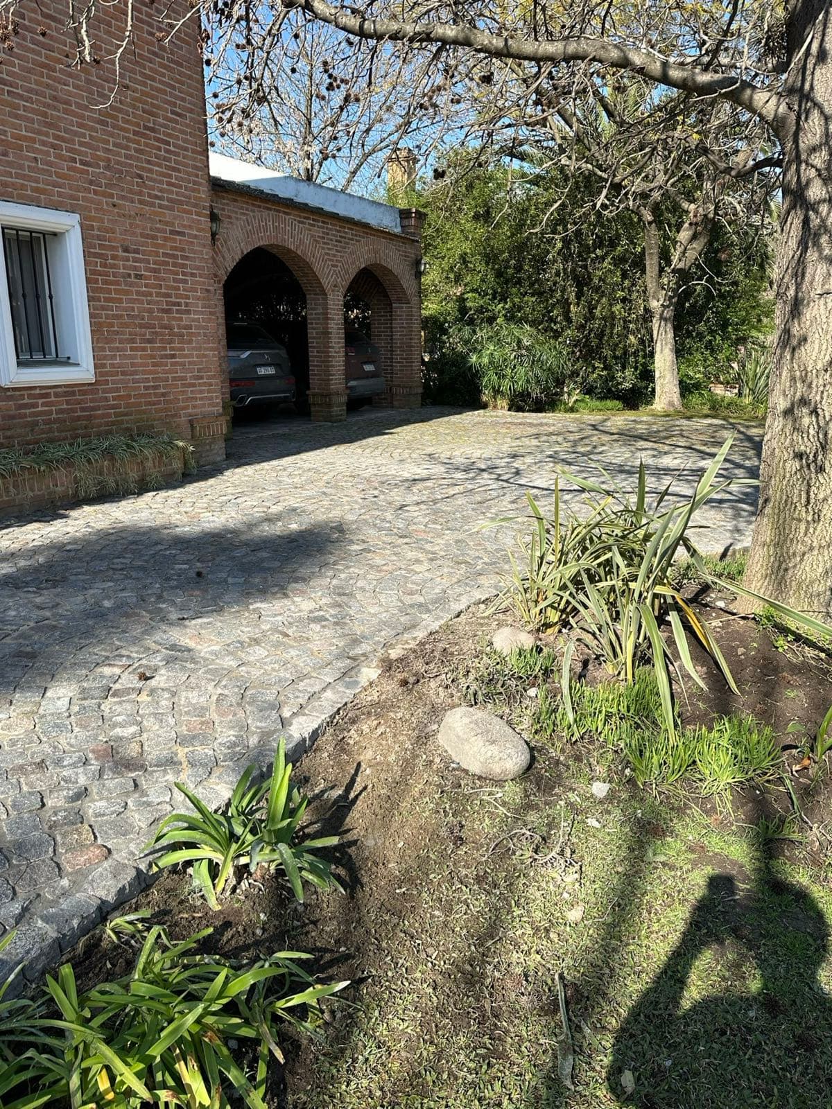 Sendero y cochera de una casa con adoquinado de piedra terminado